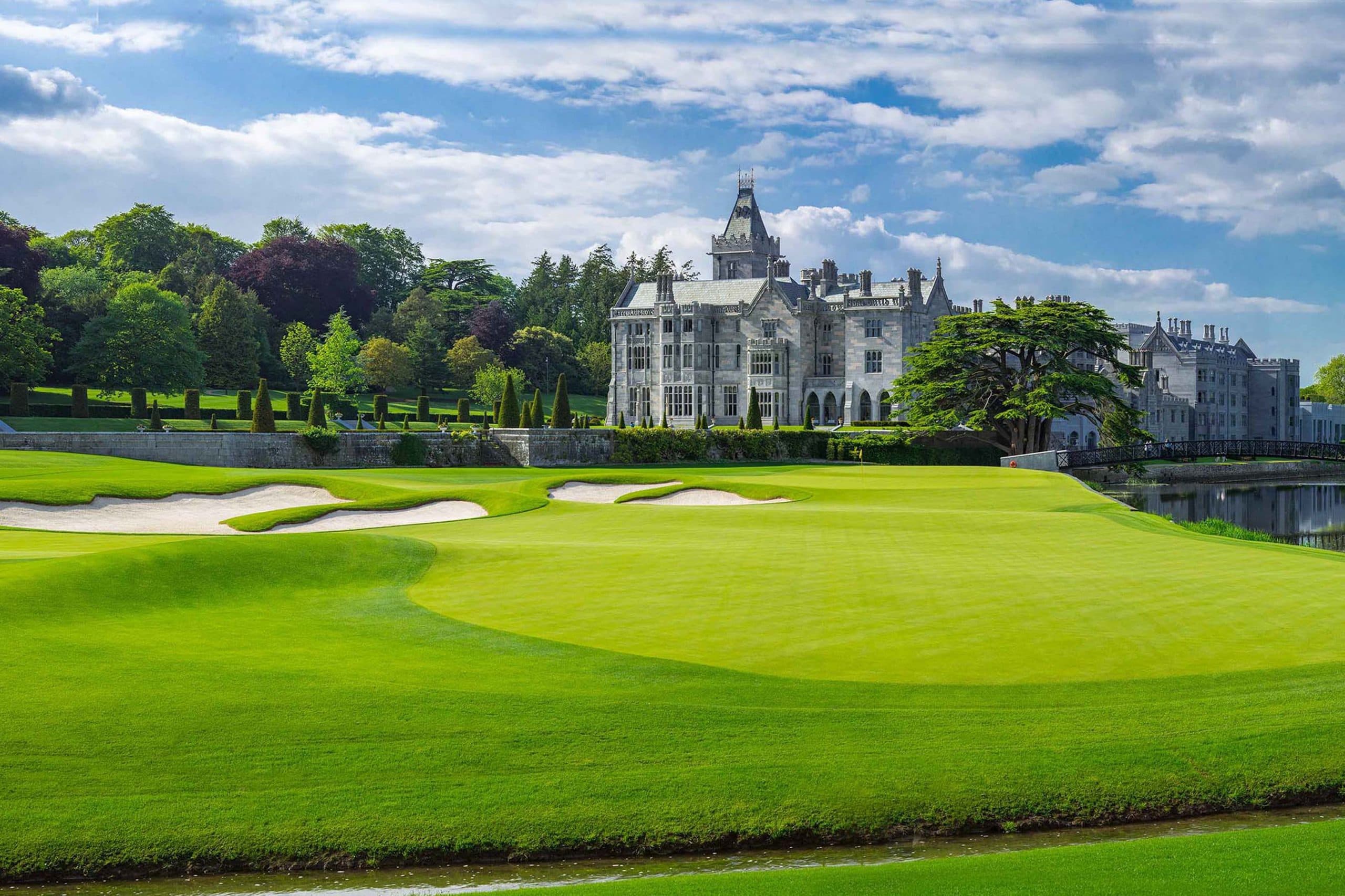 Green and stone bridge at Adare Manor with the castle beyond